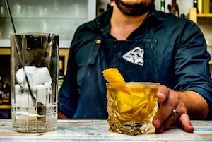 Barkeeper serviert einen Cocktail